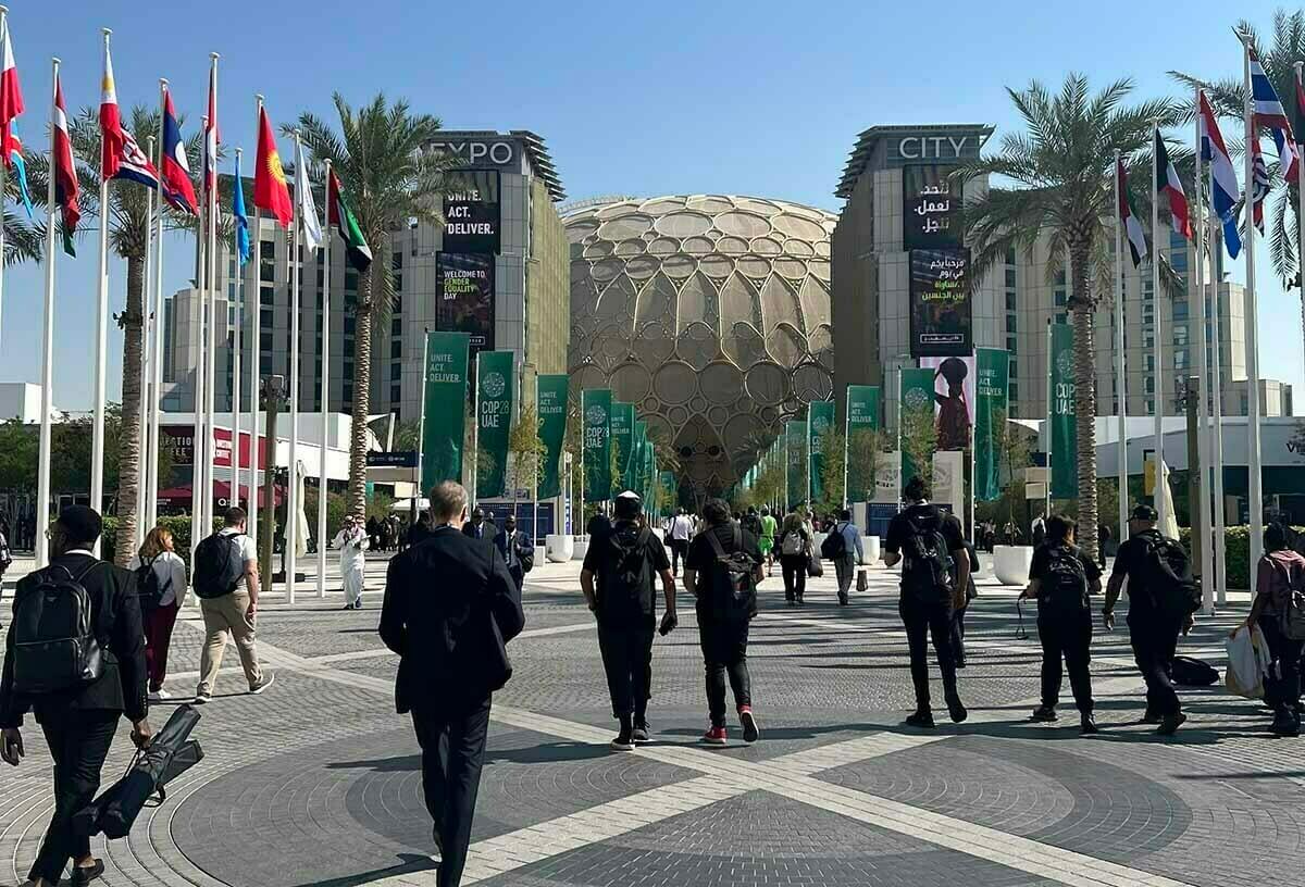 A crowd walking toward the dome at the COP28 conference in Dubai.